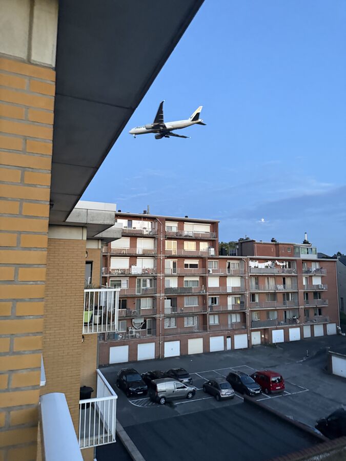 Een vrachtvliegtuig van AeroLogic in de nadering, laag boven de appartementsgebouwen aan de Woluwelaan in Diegem, met het landingsgestel al uitgeklapt.